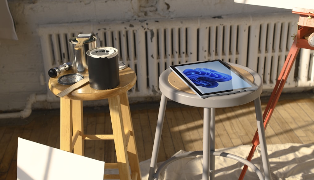 a tablet sitting on a stool next to a painting easel