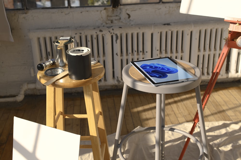 a tablet sitting on a stool next to a painting easel