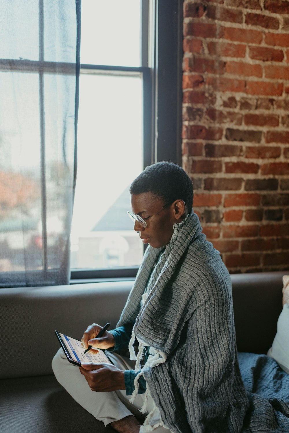 a man sitting on a couch reading a book