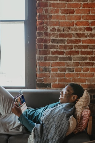 A person using a tablet in a cozy living room setting.