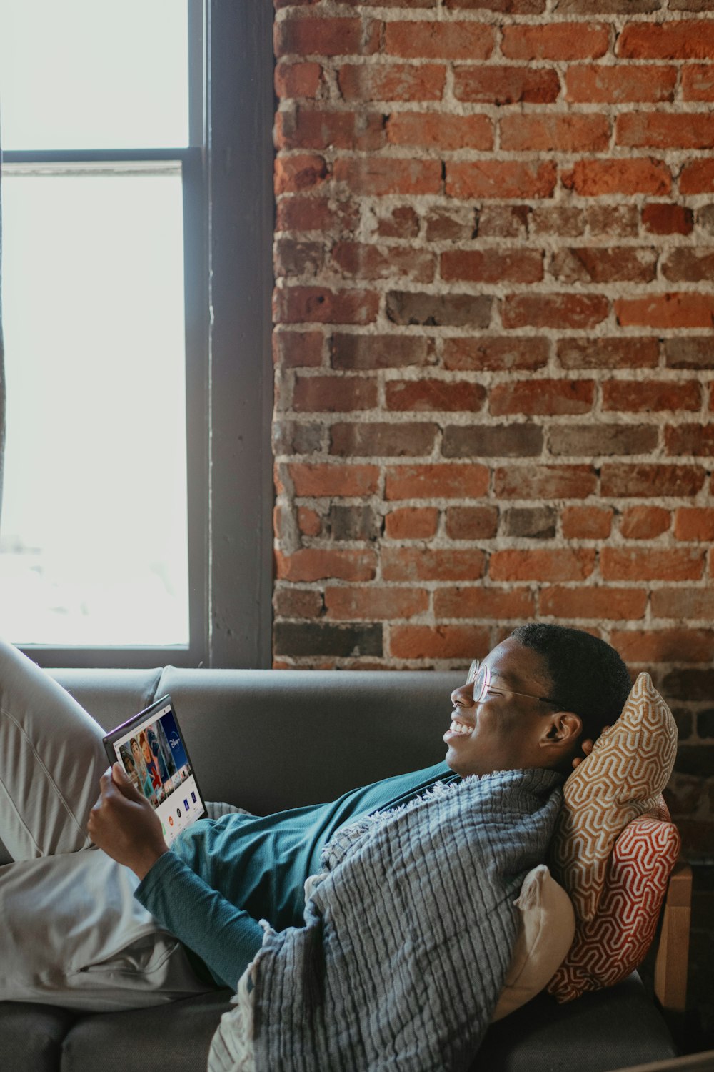 a man sitting on a couch reading a book