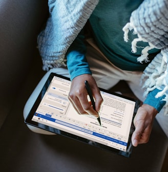 a person sitting down writing on a tablet