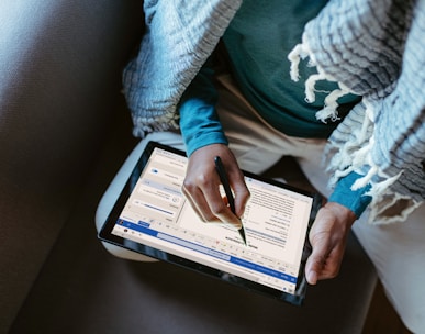 a person sitting down writing on a tablet