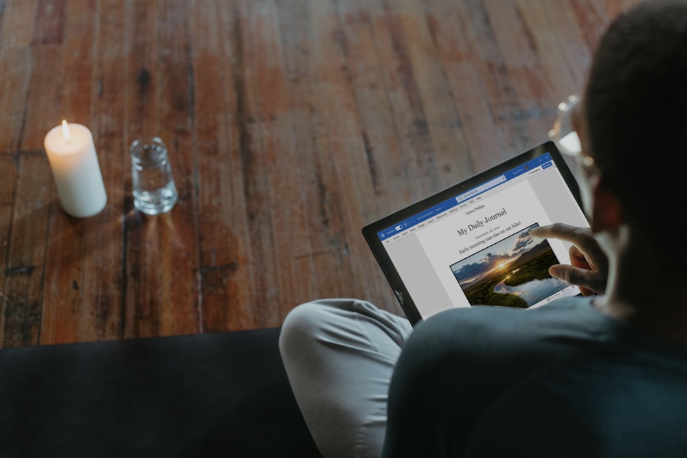 a man sitting on a couch using a laptop computer