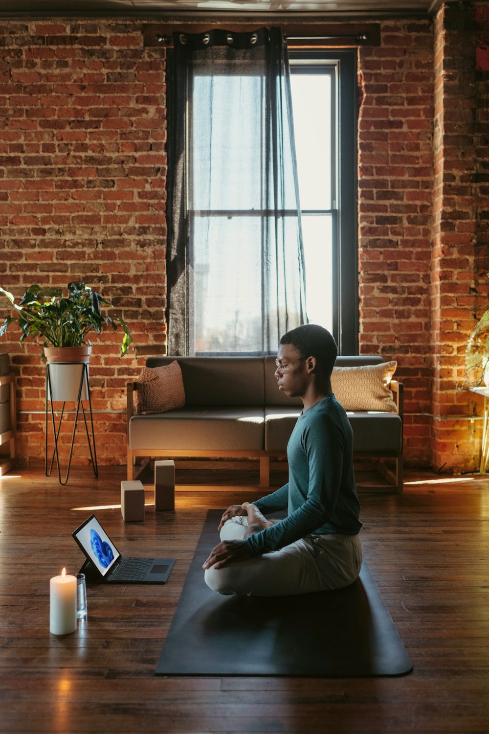 a man sitting on a yoga mat in a living room