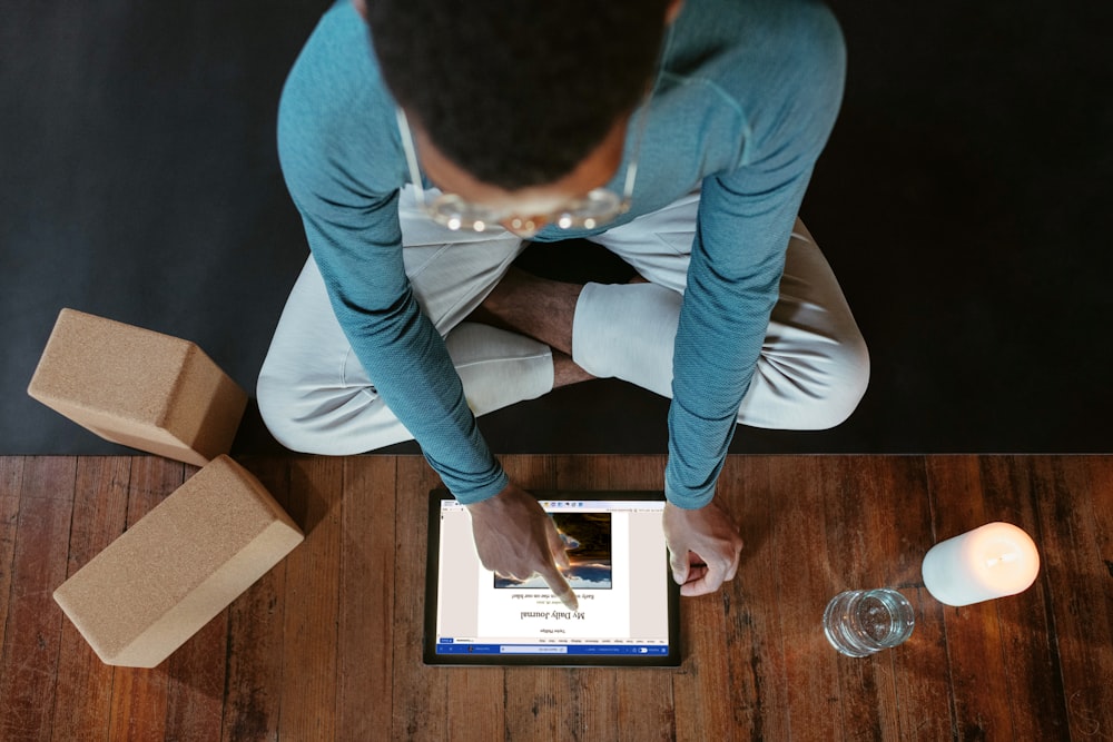 a man sitting on the floor using a tablet