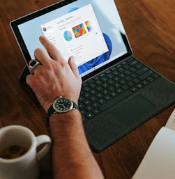 a man sitting at a table using a laptop computer