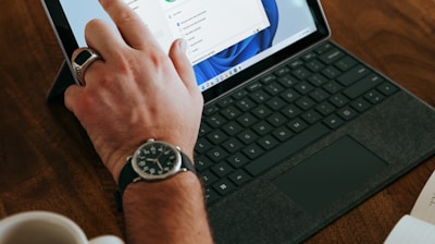 a man sitting at a table using a laptop computer