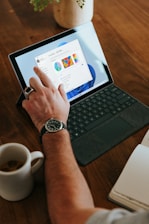 a man sitting at a table using a laptop computer