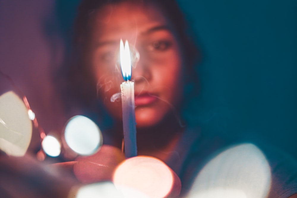 a woman holding a lit candle in her hands