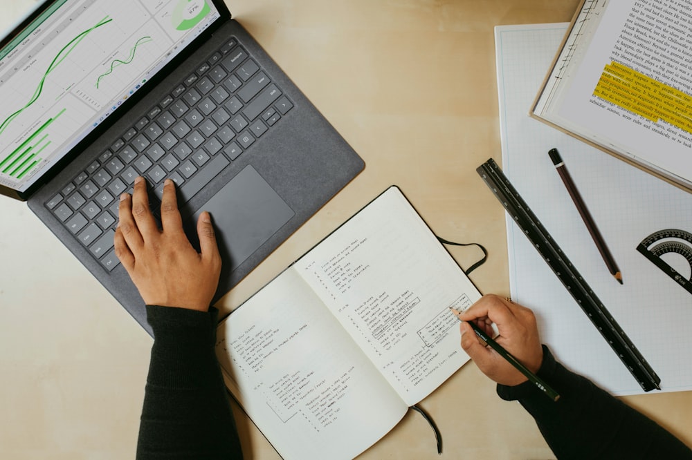 Una persona sentada en un escritorio trabajando en una computadora portátil