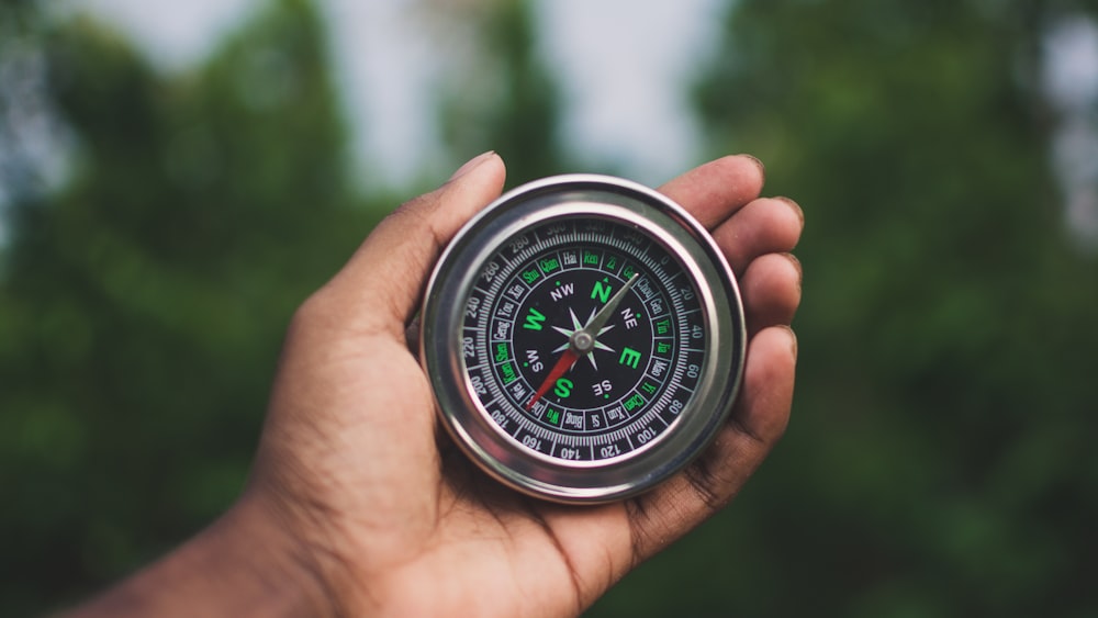 a person holding a compass in their hand