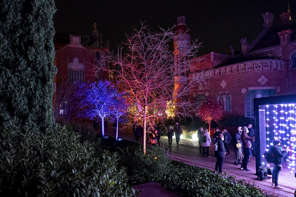 a group of people standing outside of a building at night