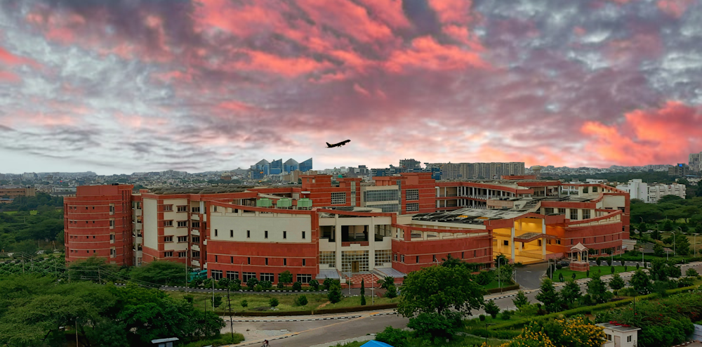 a large building with a plane flying over it