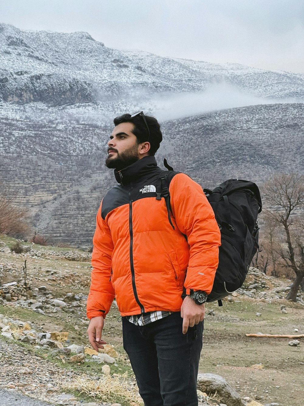 a man with a beard wearing an orange jacket
