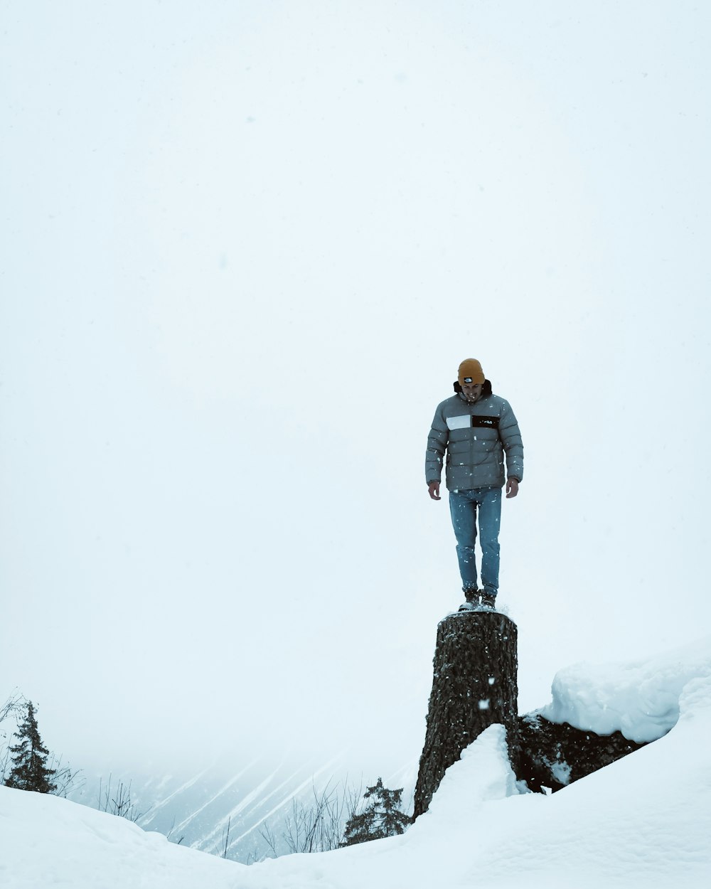 Un uomo in piedi sulla cima di una roccia nella neve