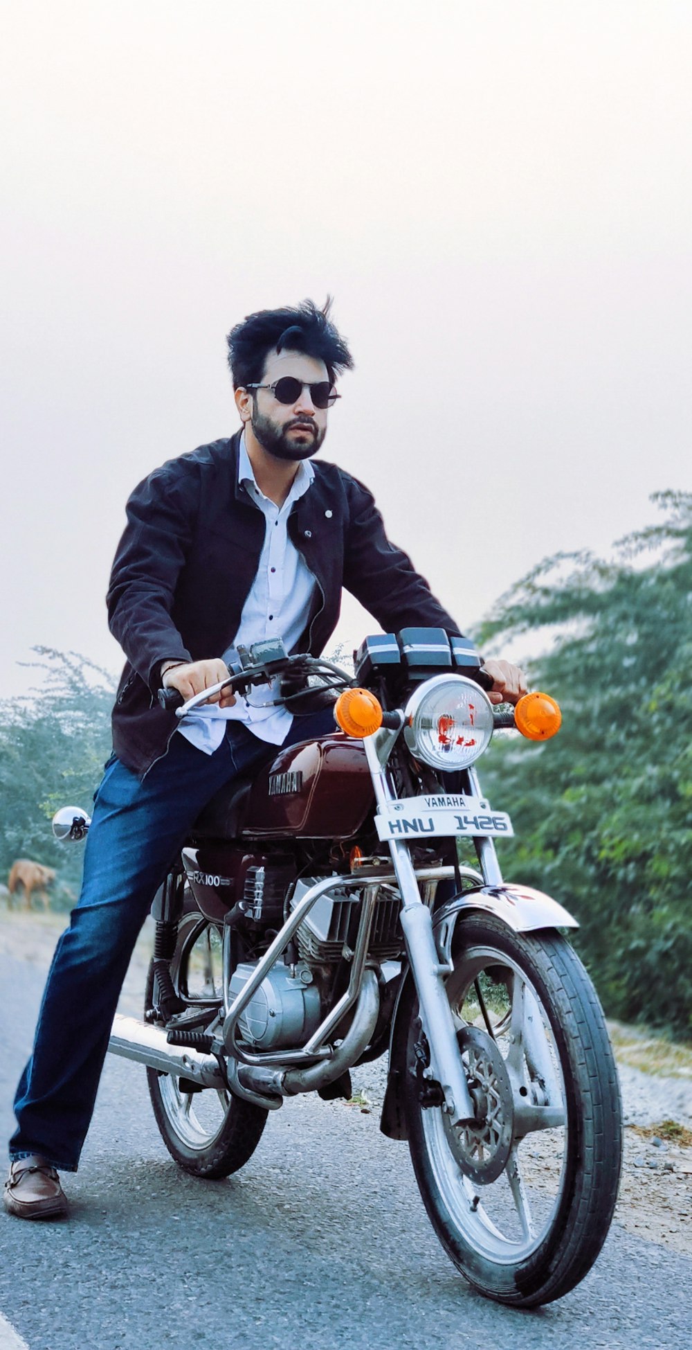 a man sitting on a motorcycle on a road