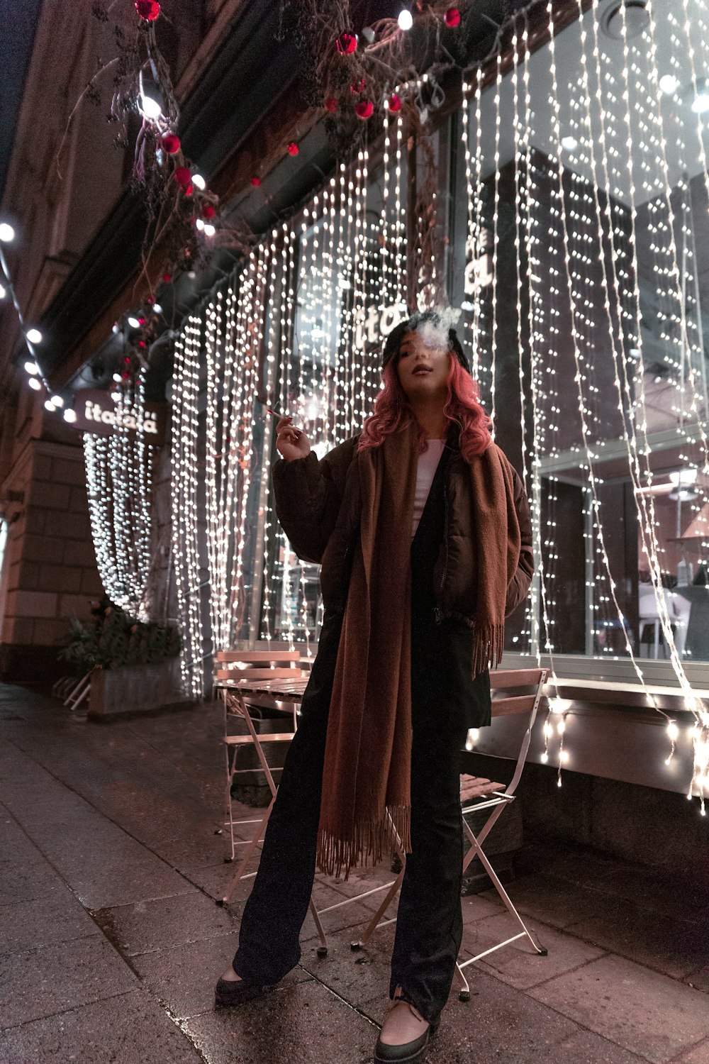 a woman standing in front of a building covered in lights