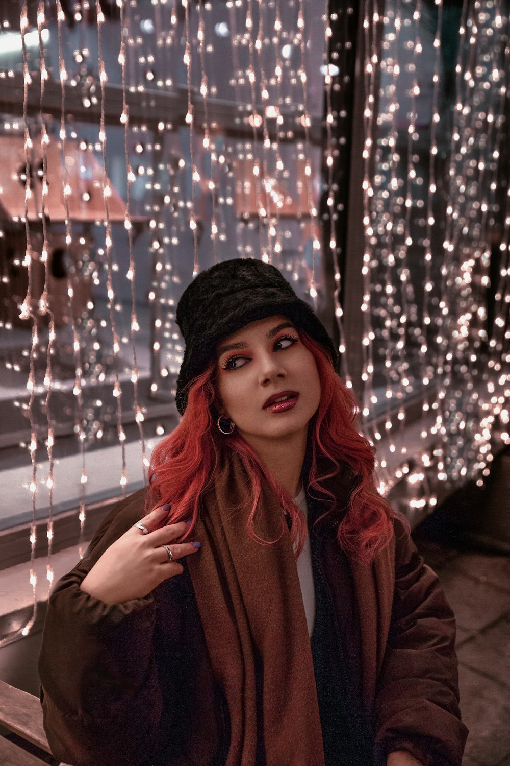 a woman with red hair wearing a black hat and scarf