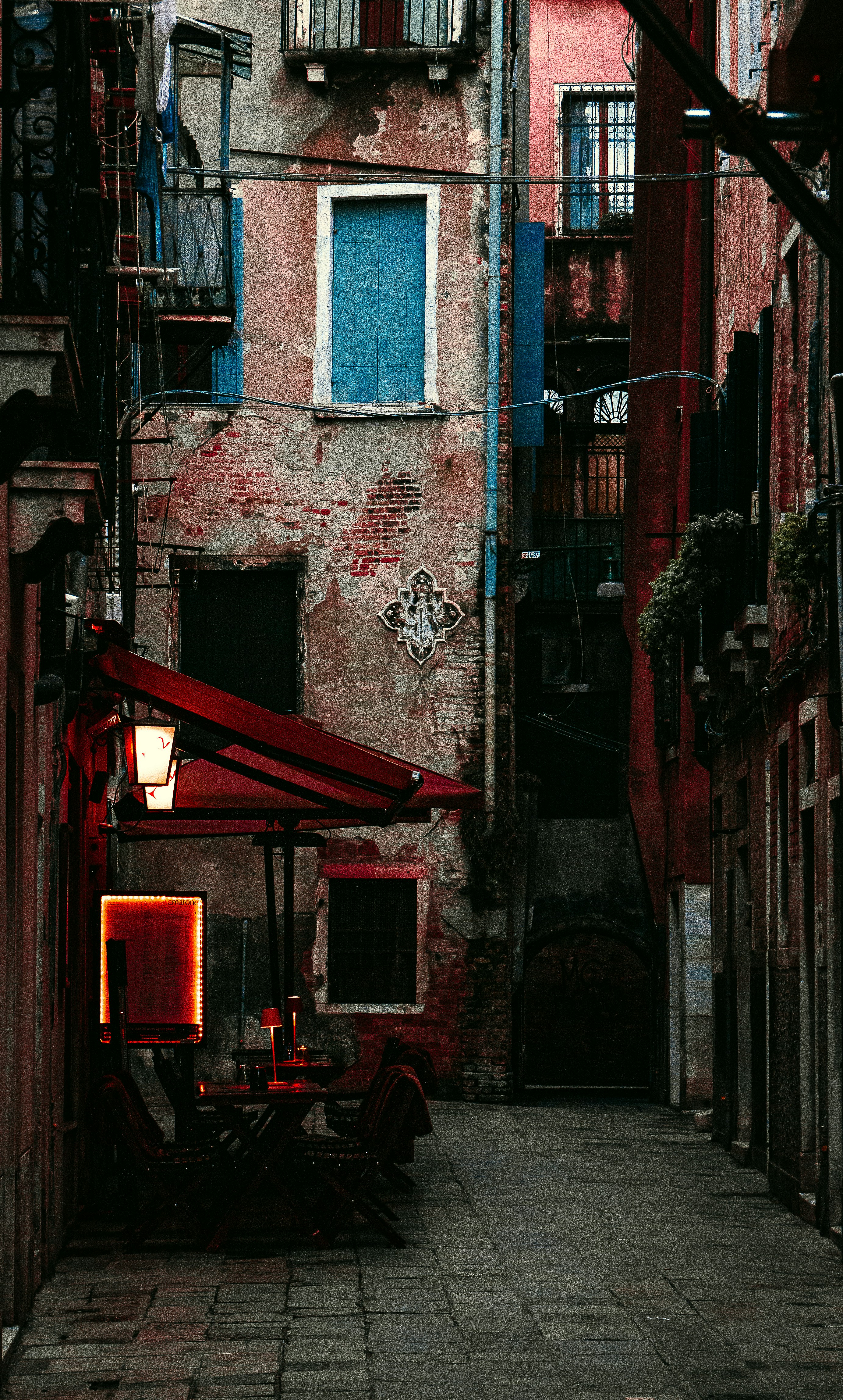 a narrow alleyway with a red awning