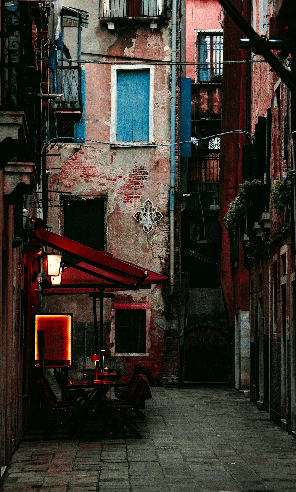 a narrow alleyway with a red awning