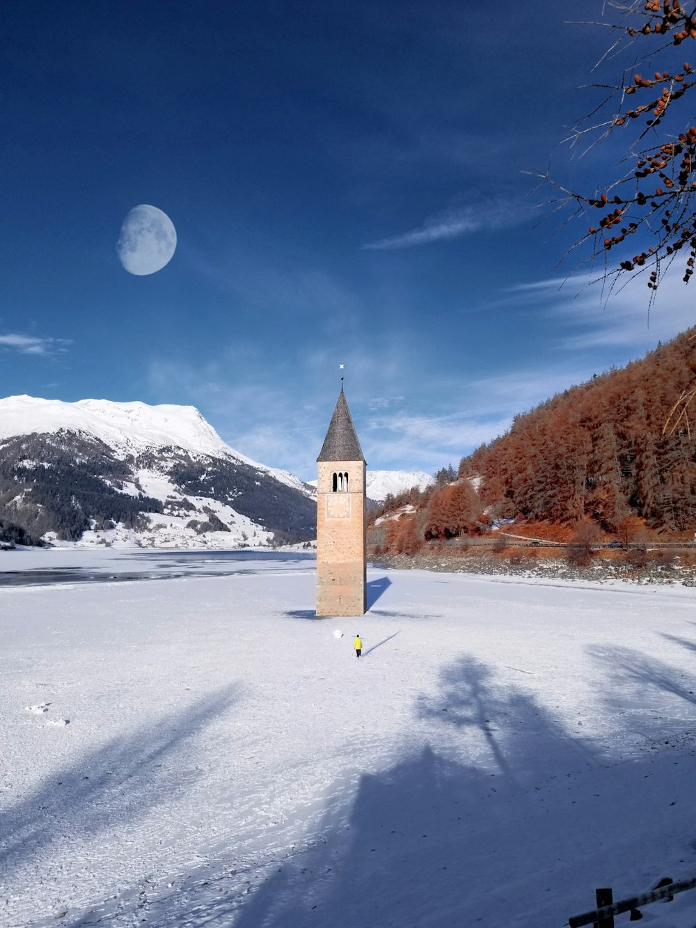 a tall tower sitting in the middle of a snow covered field