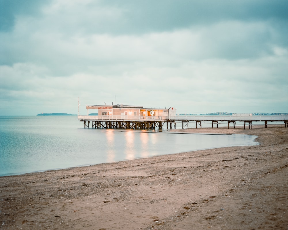 a pier on a beach with a boat in the water