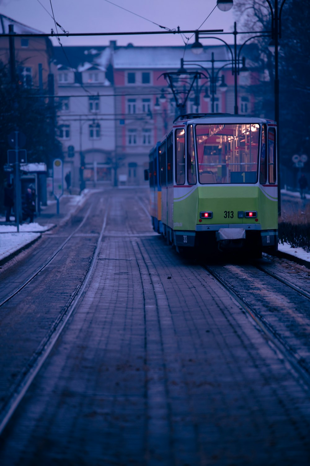 a green and yellow train traveling down train tracks