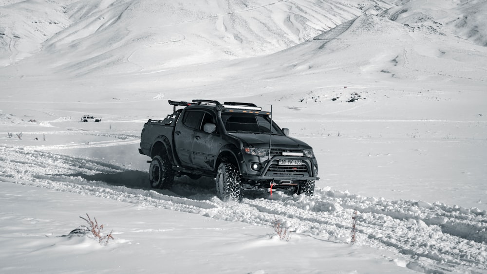 a truck is driving through the snow in the mountains