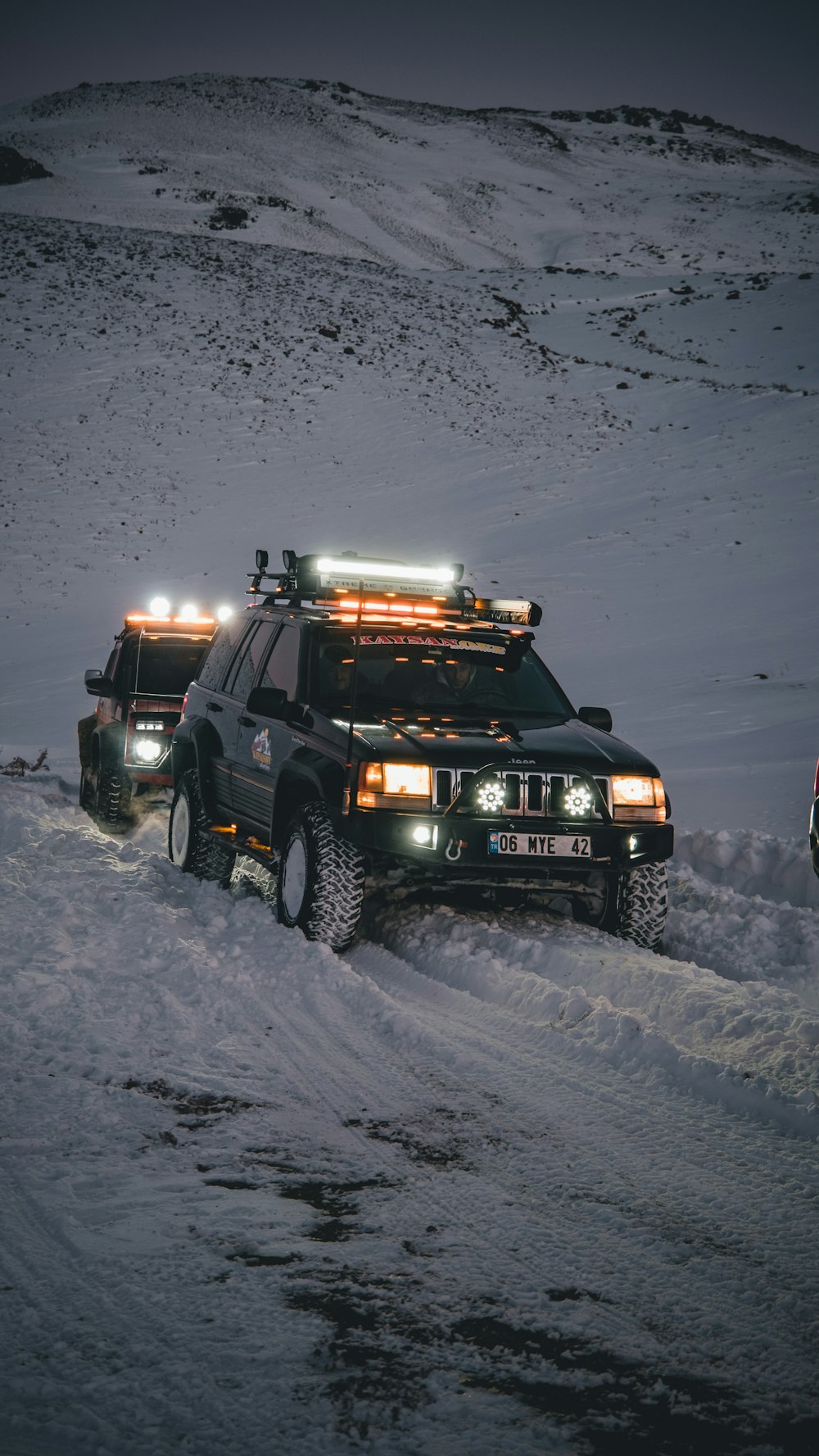 um par de caminhões que estão na neve