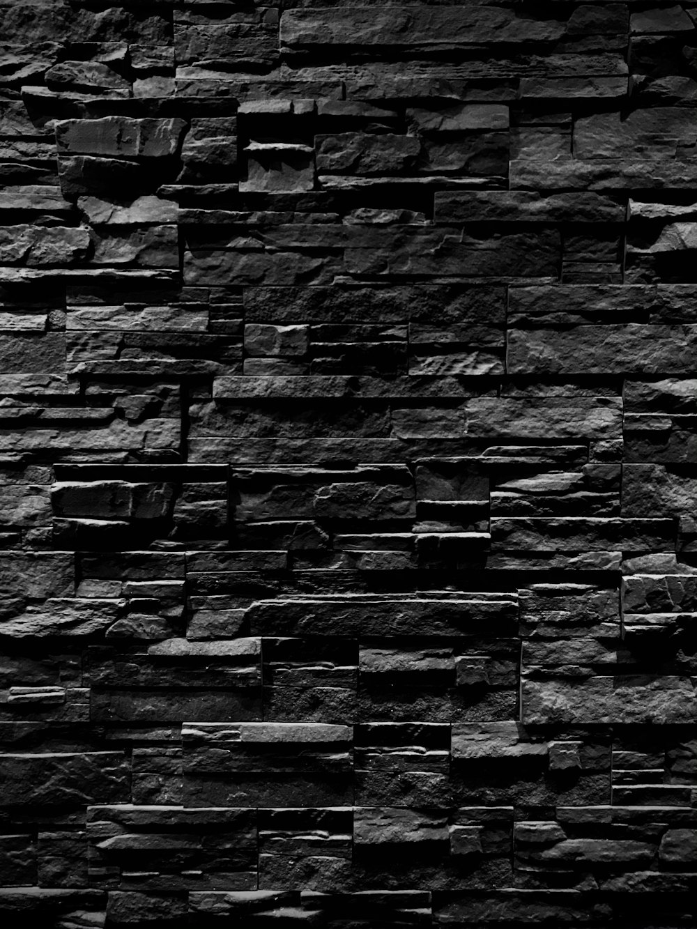 Una foto en blanco y negro de un muro de piedra