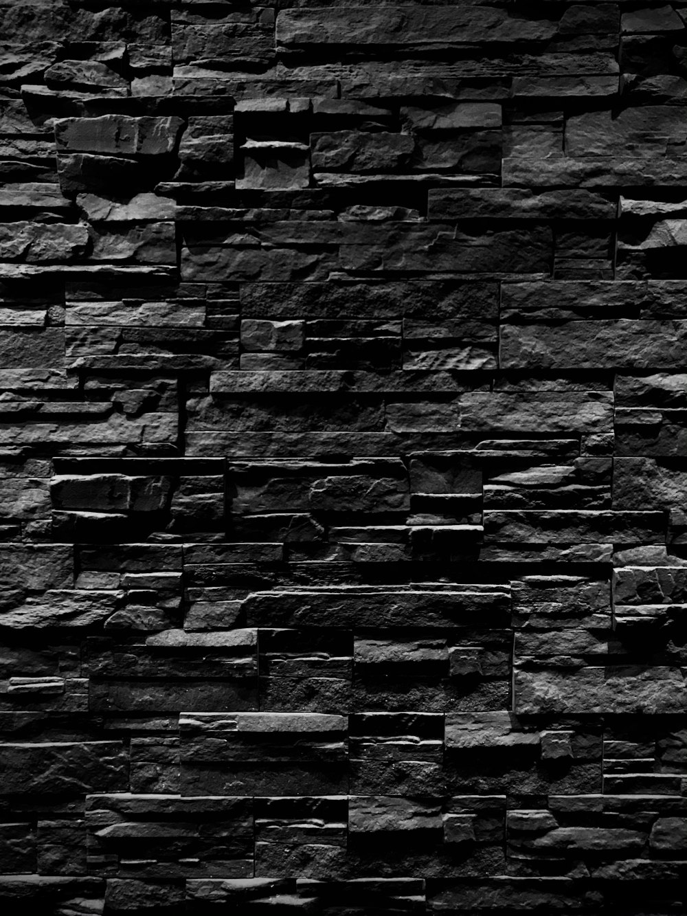 a black and white photo of a stone wall