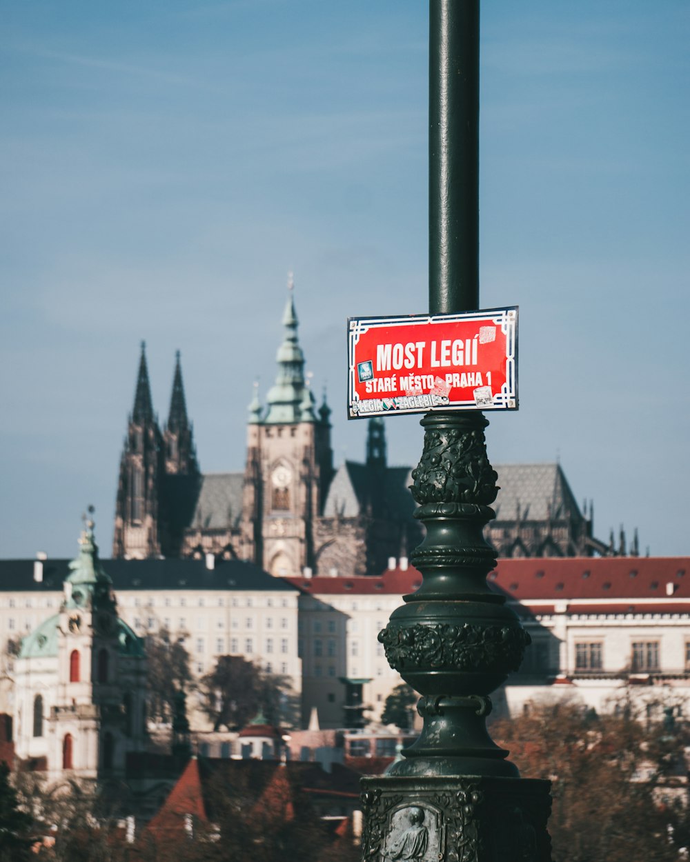 a street sign on a lamp post in front of a castle