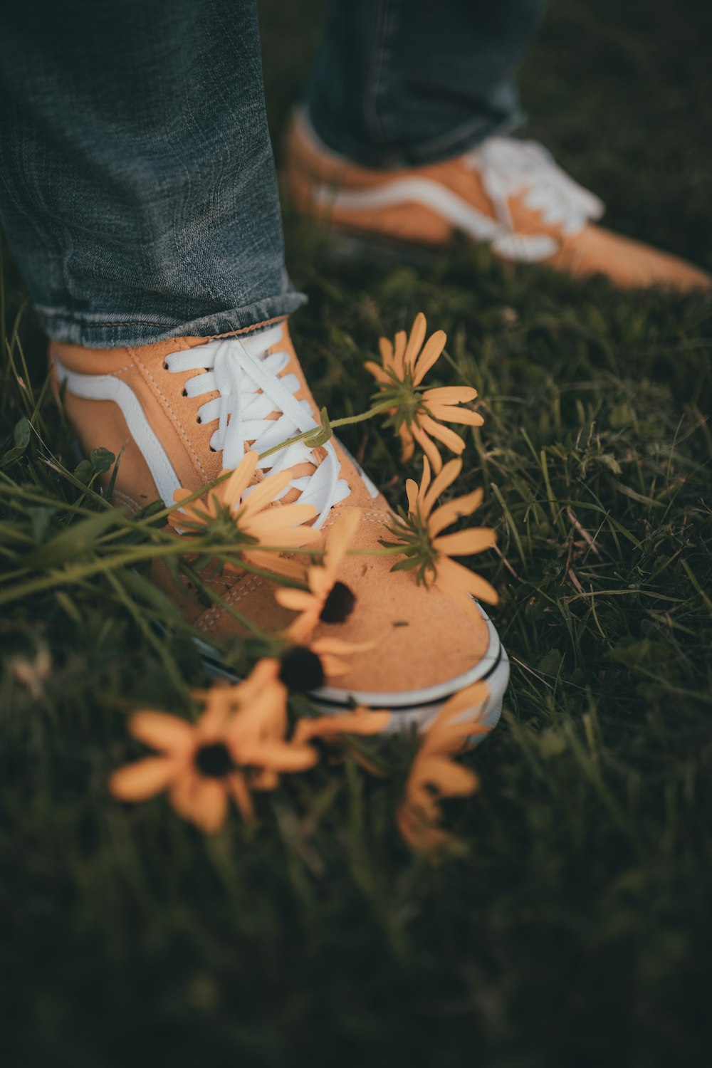 a person standing in the grass with a pair of sneakers on