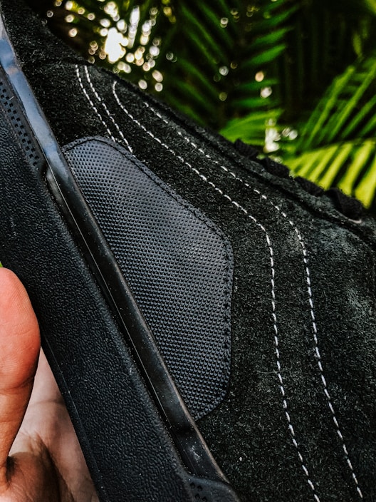 Close-up of a handcrafted sneaker with unique design details, set against an urban street backdrop.