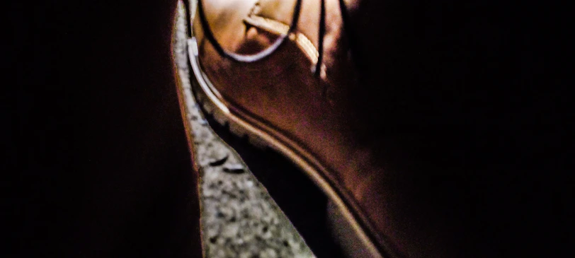 Artistic shot of enmyz footwear on concrete steps with deep shadows and high contrast.