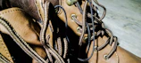 Detail shot of premium football boots laced tightly with shadows playing across the textured leather.
