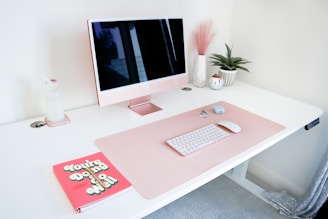 a desk with a computer and a book on it
