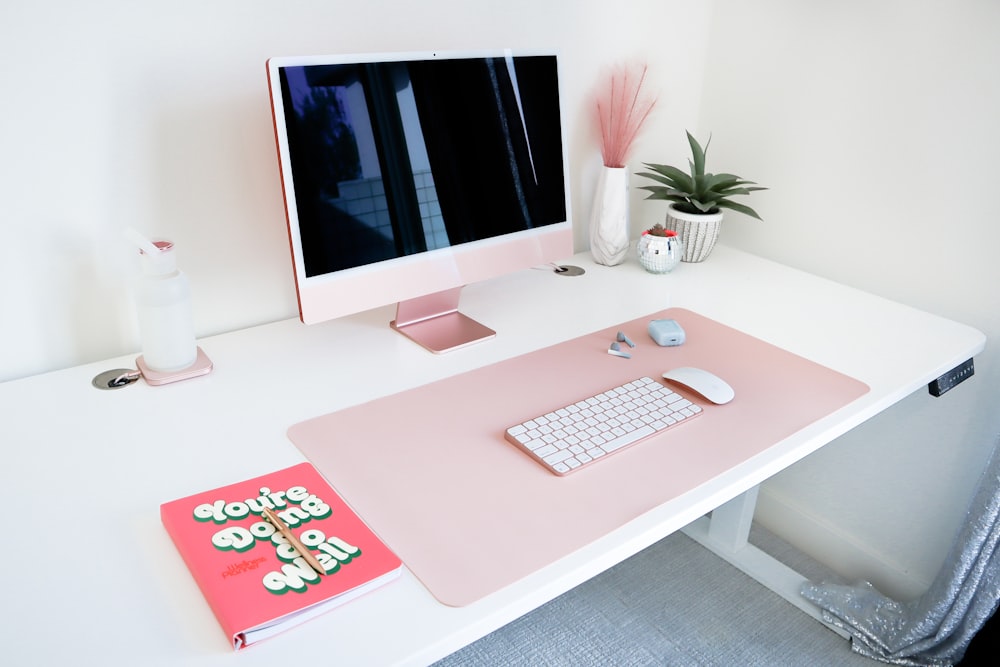 a desk with a computer and a book on it