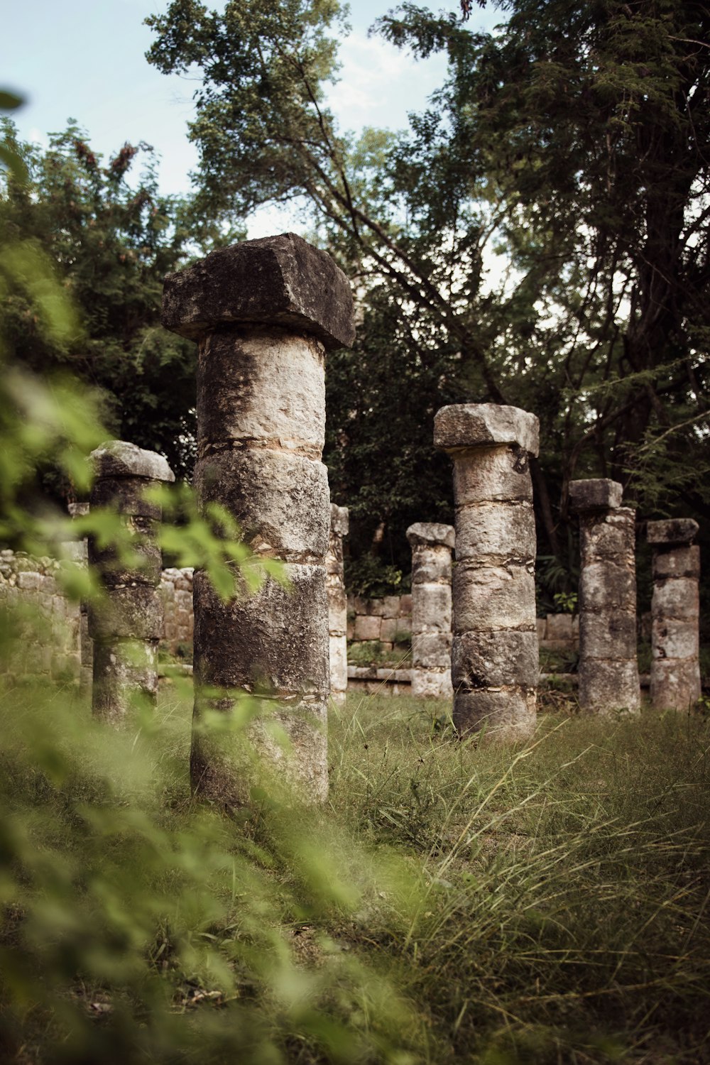 a group of stone pillars in a grassy area