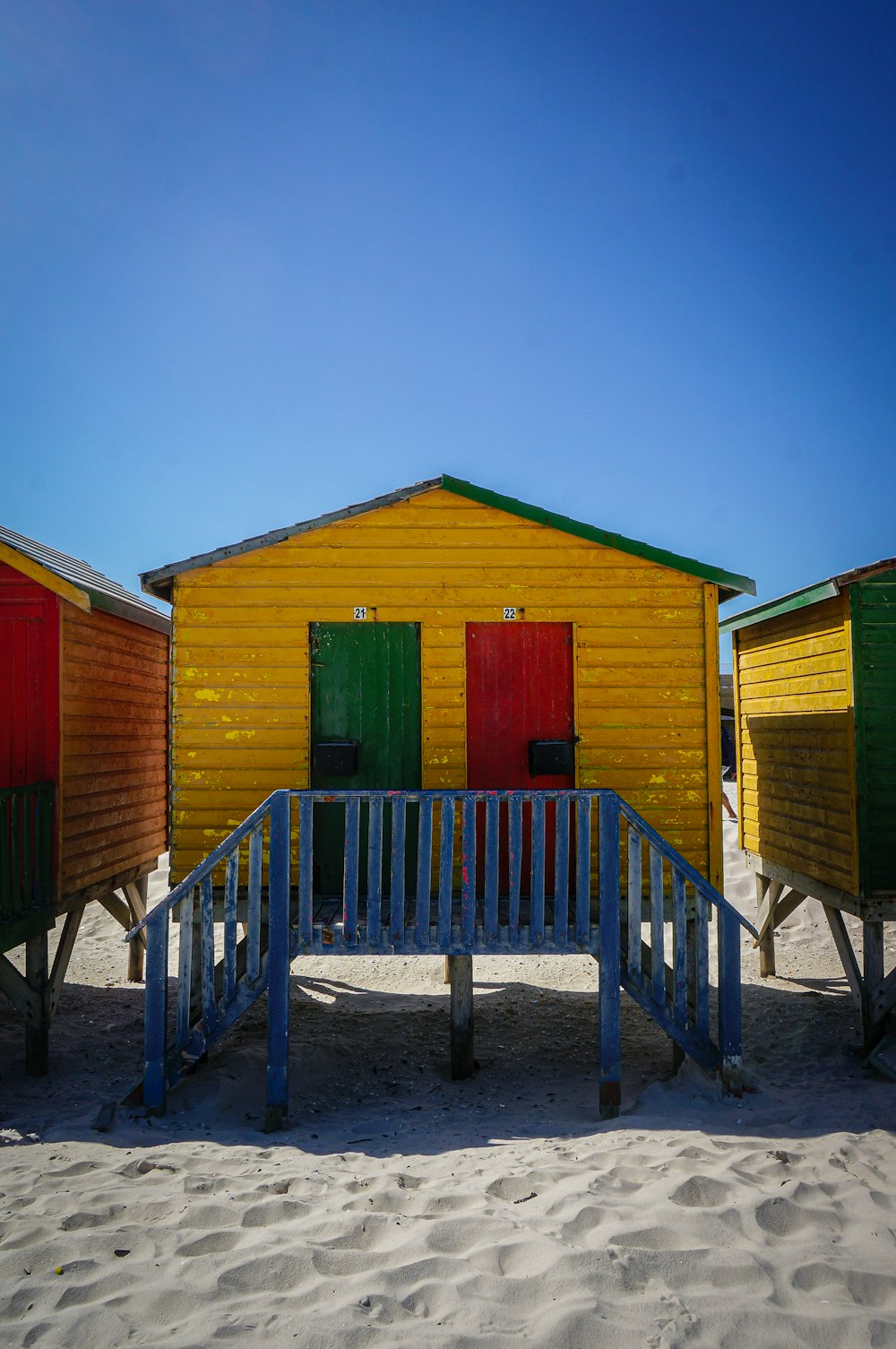 a row of beach huts sitting on top of a sandy beach