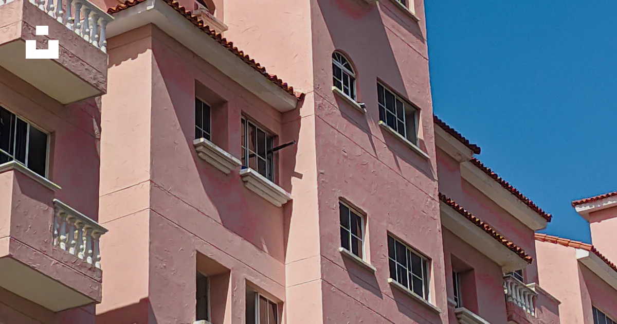 Pink Building Florida A pink building with balconies and a clock tower photo – Free Architect ...