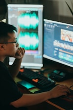  Film company: man sitting in front of two computer monitors