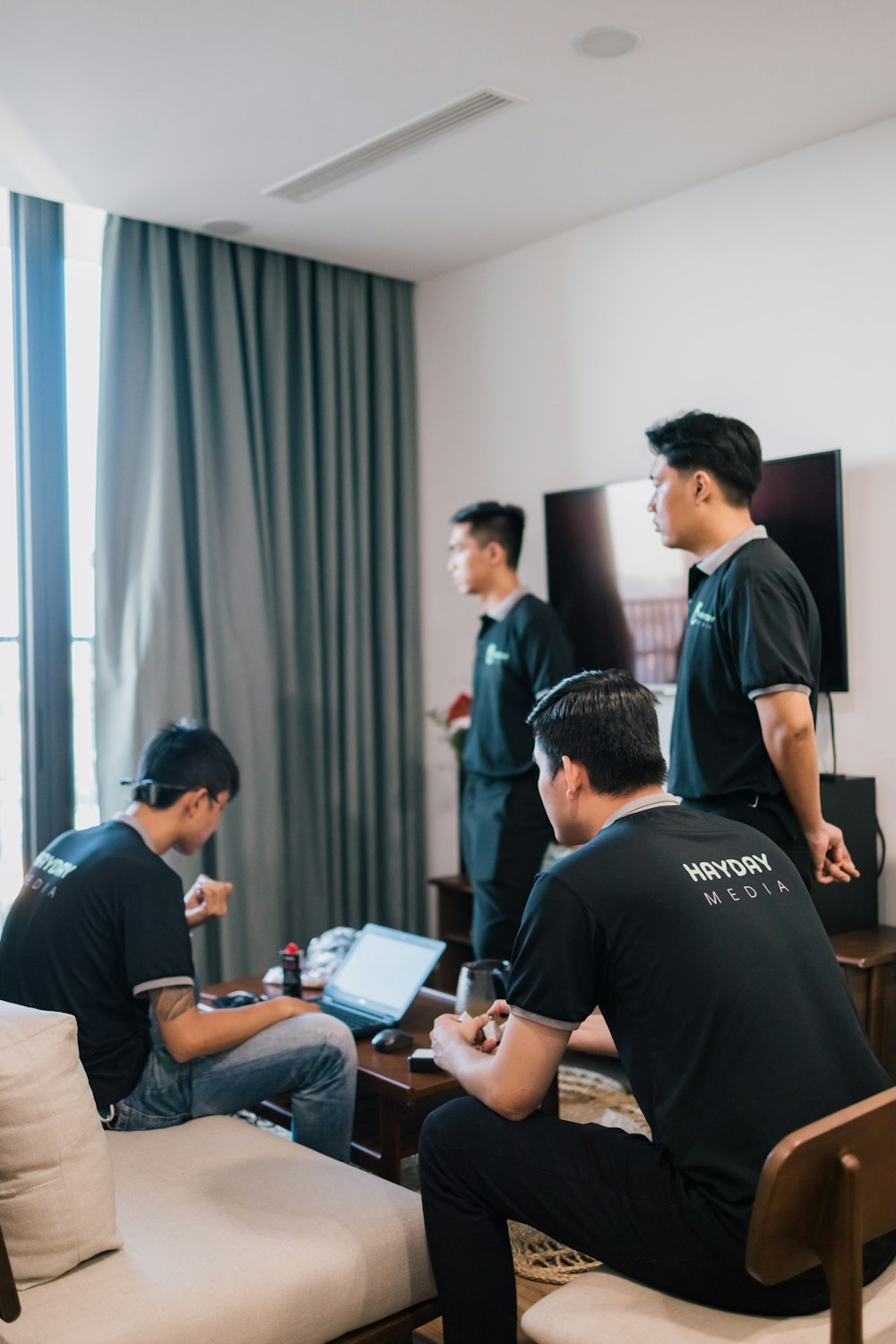 a group of men sitting around a living room together