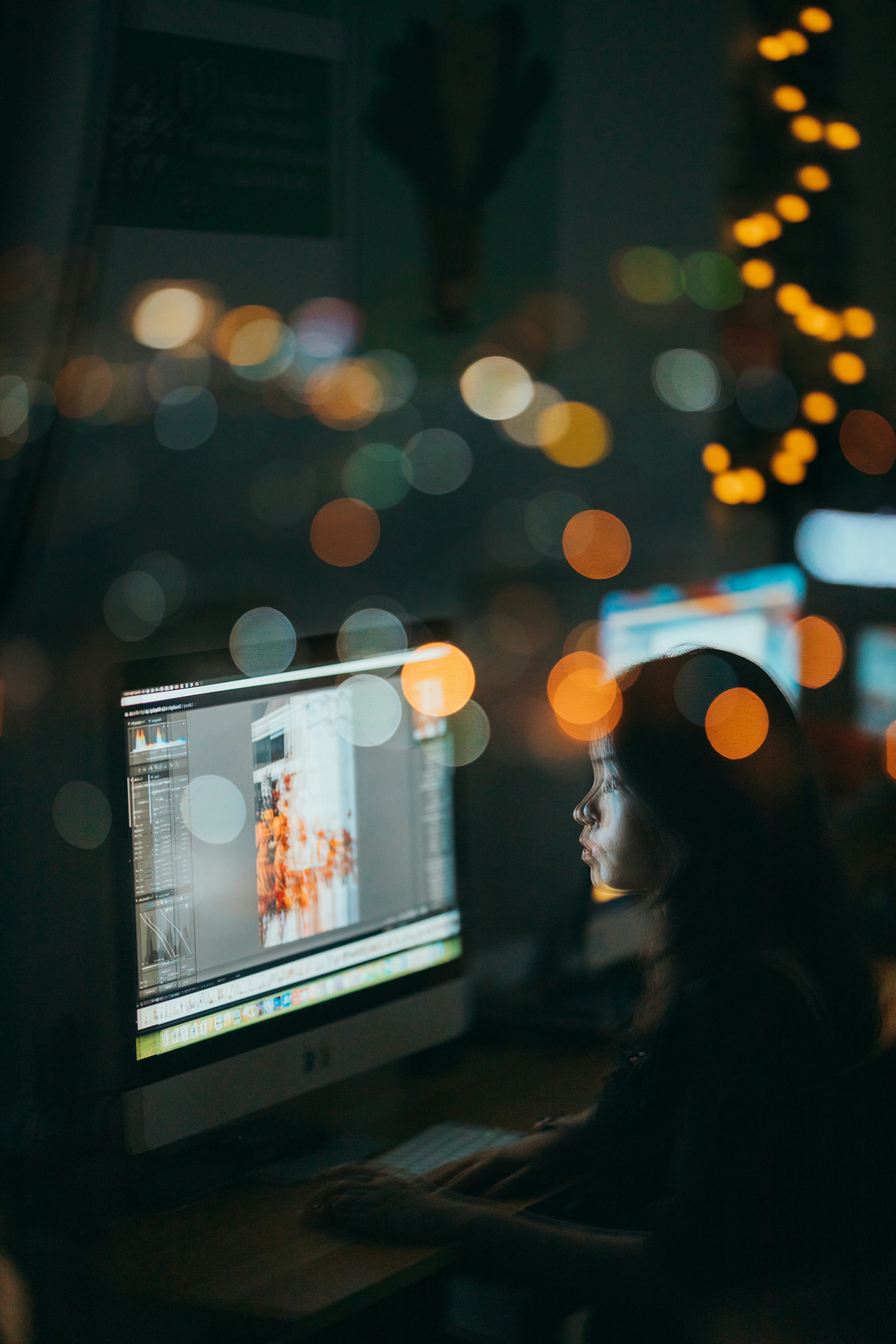 a woman sitting in front of a computer monitor