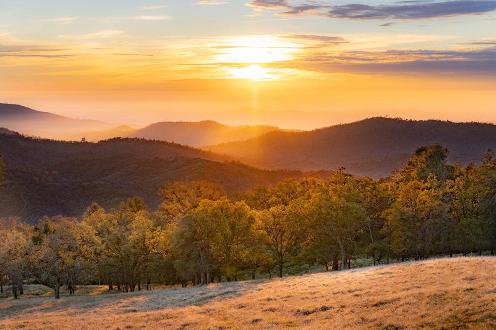 the sun is setting over a mountain range