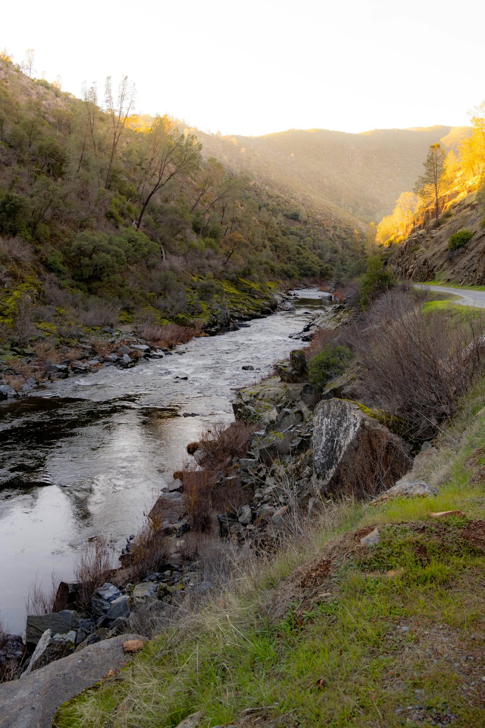 a river running through a lush green hillside