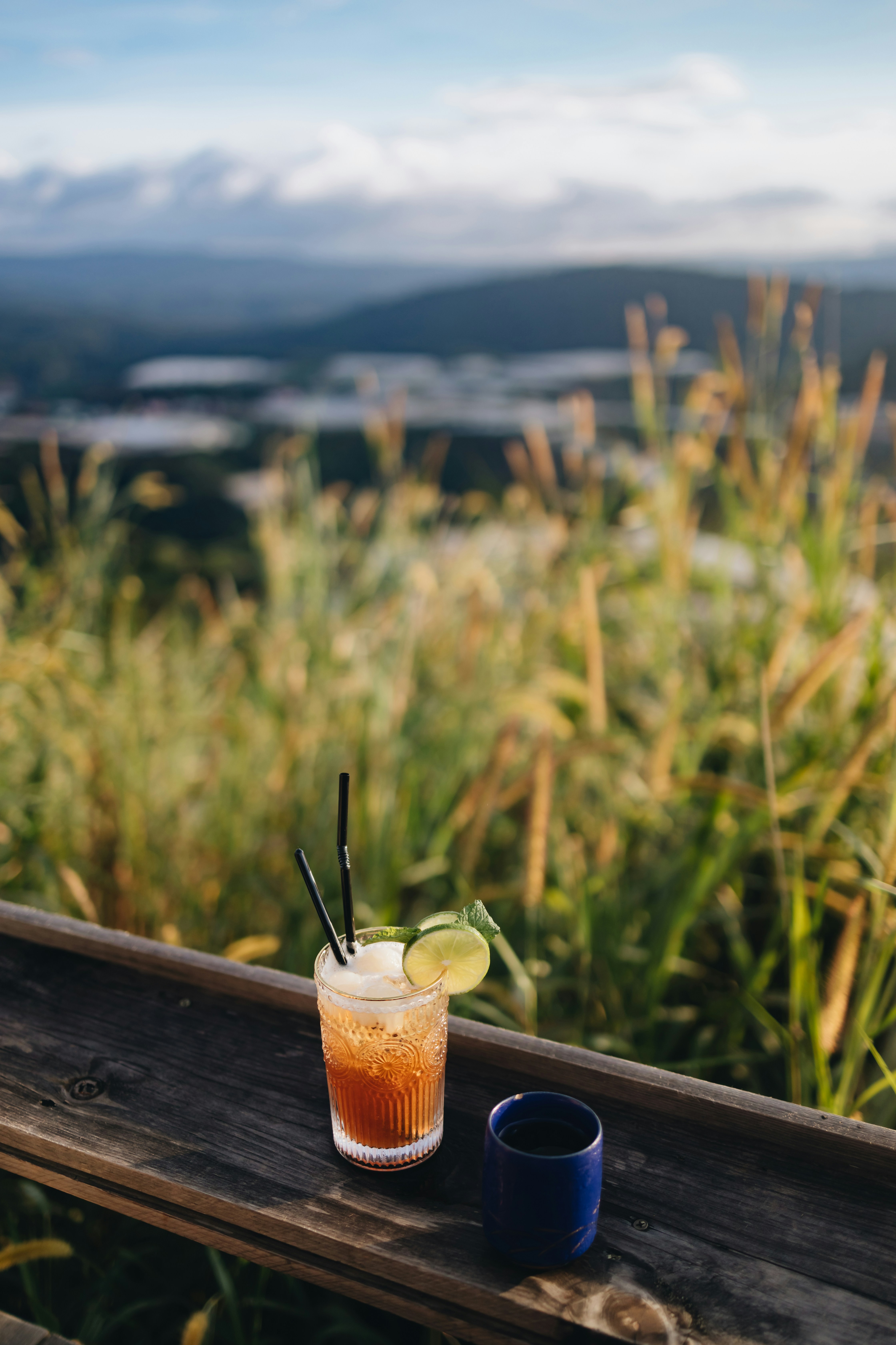a drink sitting on top of a wooden table next to a cup