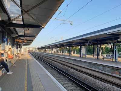 A serene metro station with people waiting for trains.
