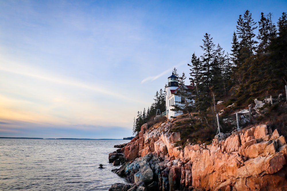 a light house on a rocky cliff near the ocean